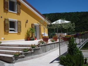 a yellow house with stairs and potted plants at Agape in Caprino Veronese