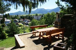 a picnic table on a brick patio with mountains in the background at Apartmány Kvetná in Rajecké Teplice