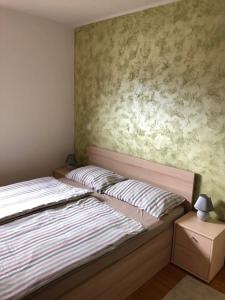 ein Schlafzimmer mit einem Bett und einer Wand in der Unterkunft Apartma NEVA in Bohinj