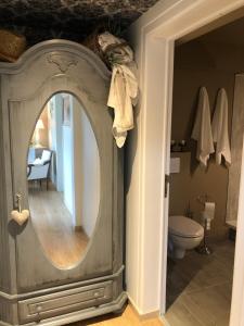 a bathroom with a mirror and a toilet at Au refuge du spéléo in Hotton