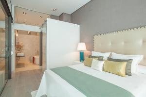 - une chambre avec un grand lit blanc et une salle de bains dans l'établissement iloftmalaga Calle Nueva Lofts, à Malaga