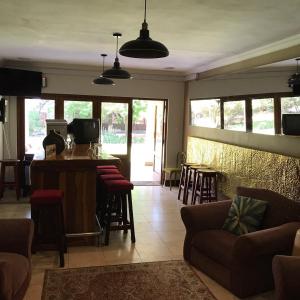 a living room with a couch and a bar with stools at OR Tambo Guest House in Kempton Park
