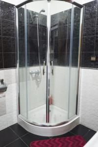 une douche avec une porte vitrée dans une salle de bain dans l'établissement Modern and Cozy Apartment, à Casablanca