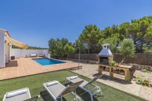 un patio trasero con piscina y cenador en Villa Astur en Binibeca