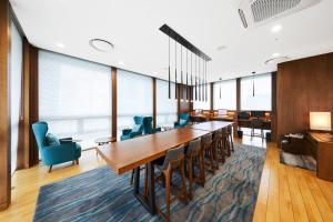 una sala de conferencias con una mesa larga y sillas en Felix by STX Hotel & Suite, en Busan