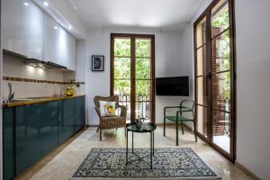 ein Wohnzimmer mit einem Tisch und einer Küche in der Unterkunft Mesones 54 in Granada