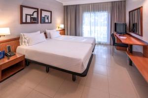 a hotel room with a large bed and a television at Ciudad de Castelldefels in Castelldefels