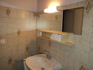 ein Bad mit einem Waschbecken und einem Spiegel in der Unterkunft Les Tilleuls in Le Biot