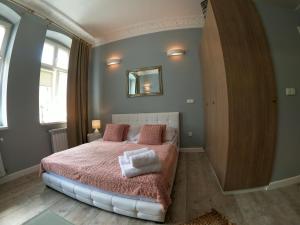 a bedroom with a bed with two towels on it at Apartamenty Apartlux in Poznań