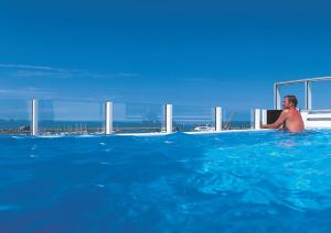 a man sitting in a swimming pool in the water at Hotel Fährhaus in Norddeich
