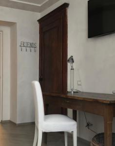 une chaise blanche assise à côté d'un bureau en bois dans l'établissement Picinque B, à Côme 8 autres photos