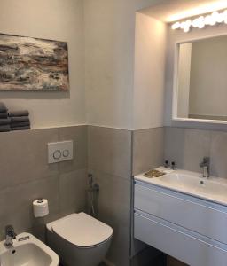 une salle de bain avec toilettes, lavabo et miroir dans l'établissement Picinque B, à Côme