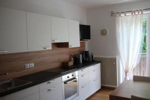 a kitchen with white cabinets and a counter top at Ferienwohnung Domitian in Millstatt