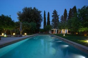 a swimming pool in a park at night at Masseria Borgo Mortella in Lecce