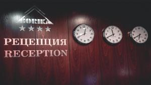 four clocks on a red wall with a sign at Borika Hotel in Chepelare