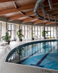 ein großer Pool in einem Gebäude mit Fenstern in der Unterkunft Borika Hotel in Tschepelare