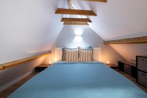 a bedroom with a blue bed in a attic at Magnifique Loft , Proche Métro Lille in Croix