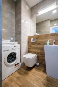 a bathroom with a washing machine and a toilet at Apartament Alfa with free parking in Poznań