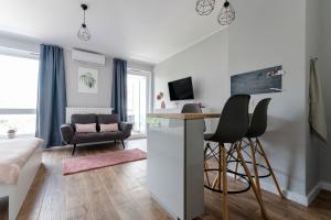 a living room with a bar with chairs and a table at Apartament Alfa with free parking in Poznań