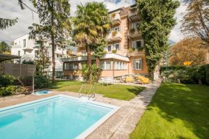 an apartment with a swimming pool in front of a building at Residence Désirée Classic & Design in Merano