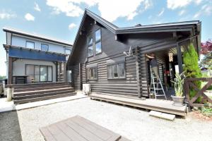 a wooden house with a ladder in front of it at Carrefour Guesthouse カルフール ゲストハウス in Yokamachi