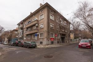 ブルガスにあるCentral Beach GUEST ROOMSの通りに面した建物とその前に駐車された車