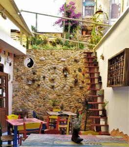 卡尼亞鎮的住宿－Poco Loco Bed & Breakfast，一间设有石墙、桌子和椅子的客房