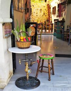 uma mesa com um cesto de frutas e um banco em Poco Loco Bed & Breakfast em Chania Town