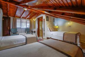 a bedroom with two beds and chairs in a room at La Paloma Hotel in Antalya