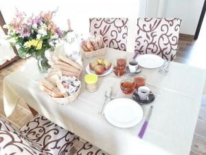un tavolo bianco con cibo e fiori di i limoni a Sorso
