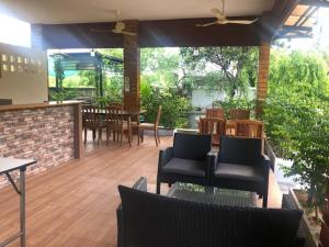 a patio with chairs and tables and a dining area at Mittrapap House in Khon Kaen