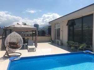 a patio with a swimming pool and an umbrella at Villa Old Batumi in Batumi