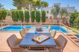 een tafel en stoelen op een patio met een zwembad bij Villa Es Ratolí in Cacla D'or