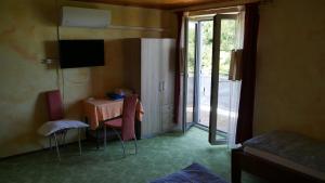 Habitación con mesa, sillas y TV. en Guest Accommodation Palma, en Portorož