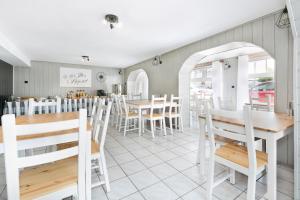 a restaurant with white chairs and tables and a counter at Przyjaciół 13 in Mielno