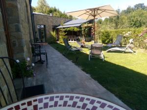 a patio with chairs and an umbrella in a yard at Boomerang Guest House in Apriltsi