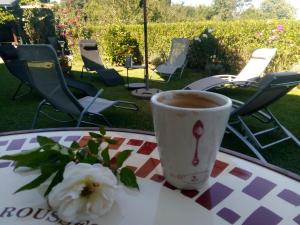 a cup of coffee and a flower on a table at Boomerang Guest House in Apriltsi