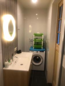 a bathroom with a washing machine and a sink at Texelduinen59 in De Koog