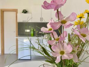 a vase filled with pink flowers on a table at Kristalni Slap Kravice in Ljubuški