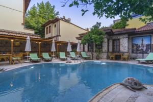 a large swimming pool with chairs and umbrellas at La Paloma Hotel in Antalya