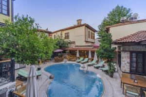 an outdoor swimming pool with chairs and a resort at La Paloma Hotel in Antalya