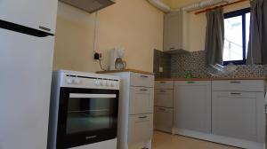 a kitchen with a stove and white cabinets at Panoramic sea view apartment in Polis-Latchi in Polis Chrysochous