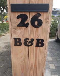 una puerta de madera con los números b y c en ella en B&B Marijke, en De Koog