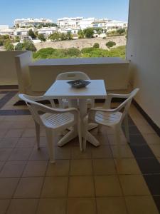 ラゴスにあるO Cantinho do Sol Lagosの白いテーブルと椅子、ビーチビュー