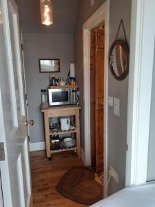 a small kitchen with a microwave on a table at Black Stair Cottage in Helensburgh