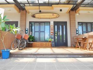 a surfboard is hanging on the front of a house at Wave backpackers in Toucheng