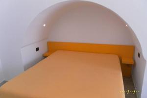 ein Schlafzimmer mit einem orangenen Bett in einem weißen Zimmer in der Unterkunft accogliente monolocale pieno centro in Galatina