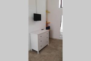 Zimmer mit einem weißen Schrank und einem TV an der Wand in der Unterkunft accogliente monolocale pieno centro in Galatina