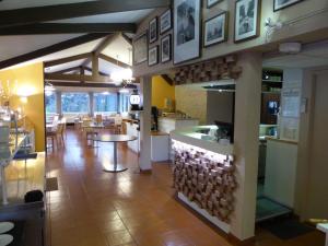 a restaurant with a kitchen and a dining room with tables at Hotel & Restaurant Heliotel in Montferrier-sur-Lez