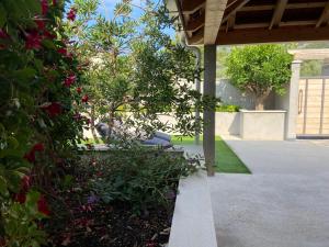 a house with a garden with flowers and a porch at Apartmani Ortolio in Viganj